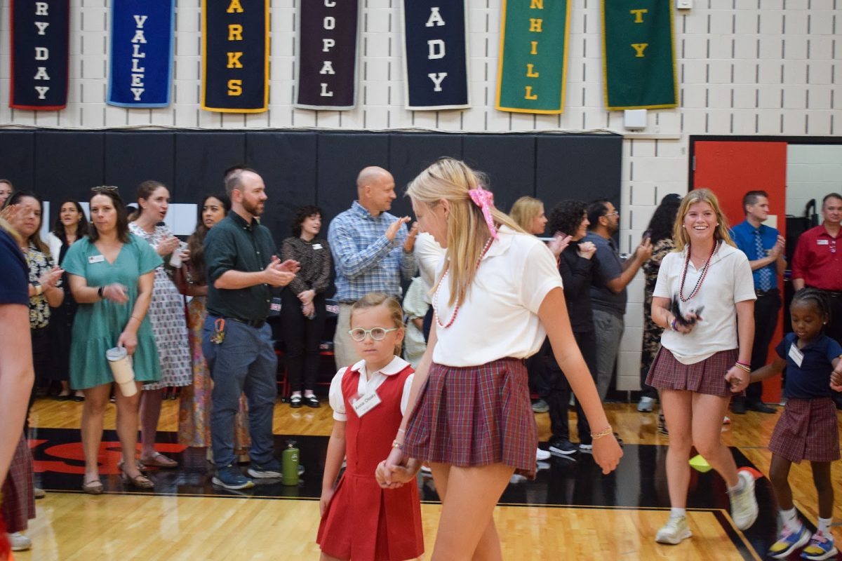 Senior Ava Powell welcomes first grade student Annie Olasky to St. John's. 