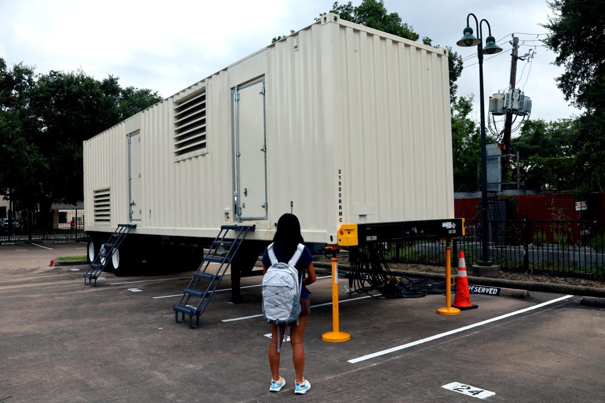 Review staffer Annie Li inspects the 90,000-pound generator parked in the Lower School lot. 
